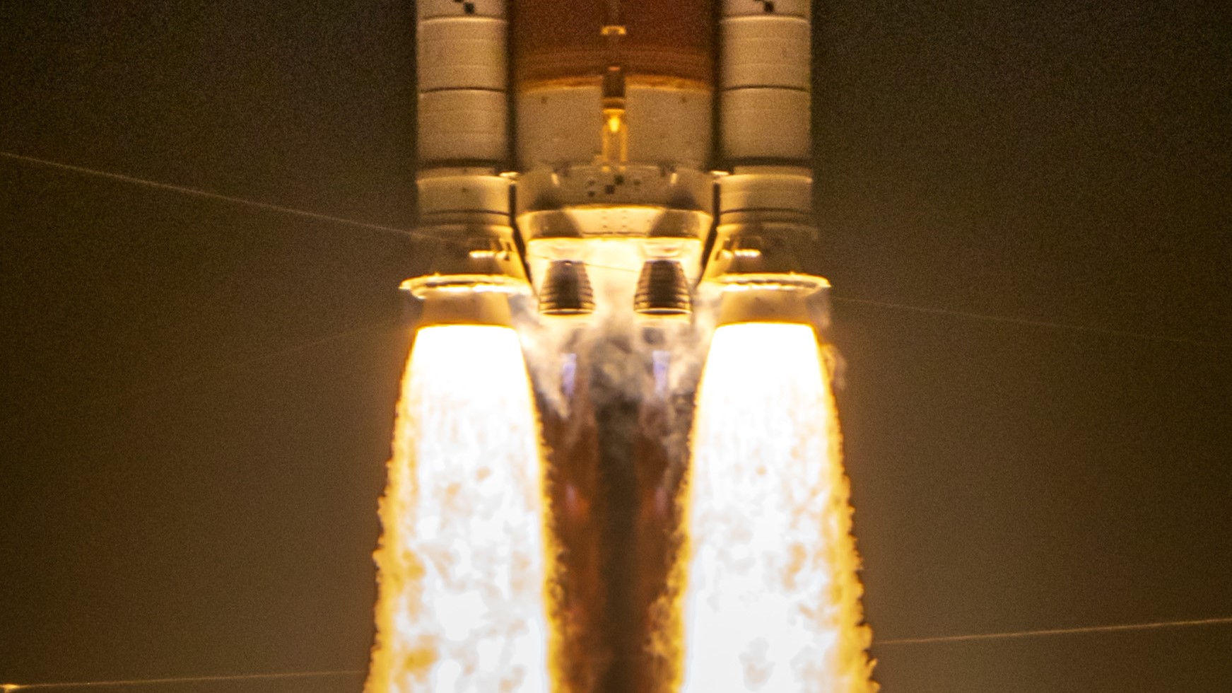 航天图片资料 · two massive side booster spew yellow orange fire lifting the core stage of a rocket as two main engines also ignite