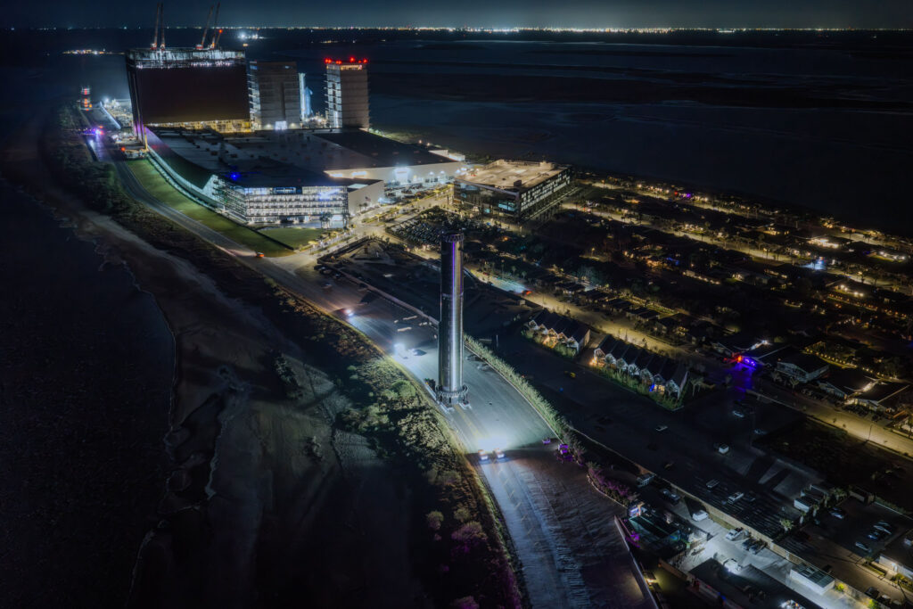 航天图片资料 · An aerial view of SpaceX Starbase, Texas, showing the Mega Bays, the Starfactory in the background as Booster 41 leaves the production site toward the launch pad.