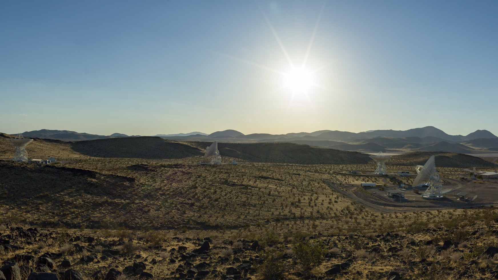 航天图片资料 · several antennas sit under a blue sky and blazing sun.