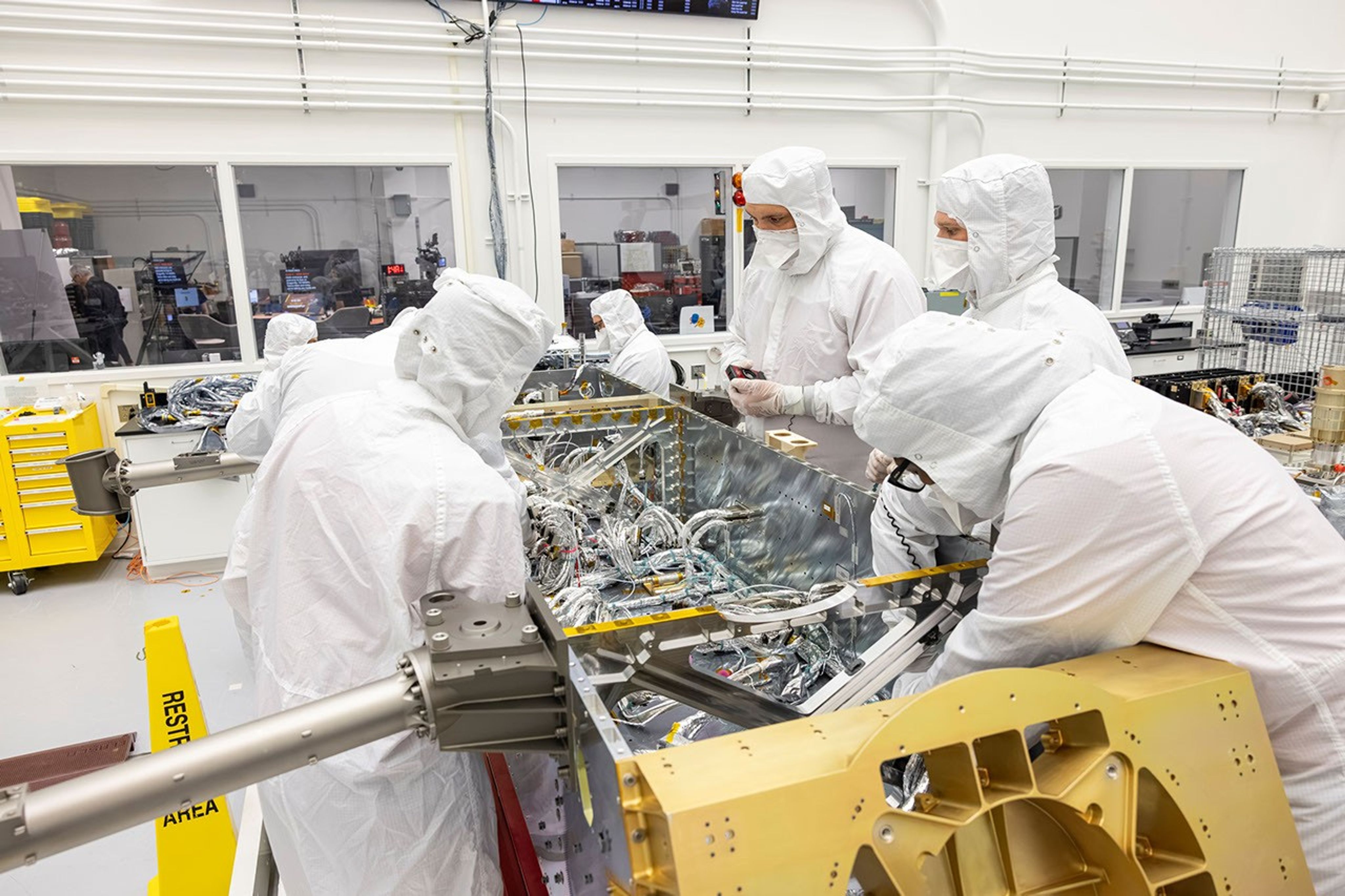 航天图片资料 · Workers attach electrical wiring to various spacecraft system components inside a clean room.