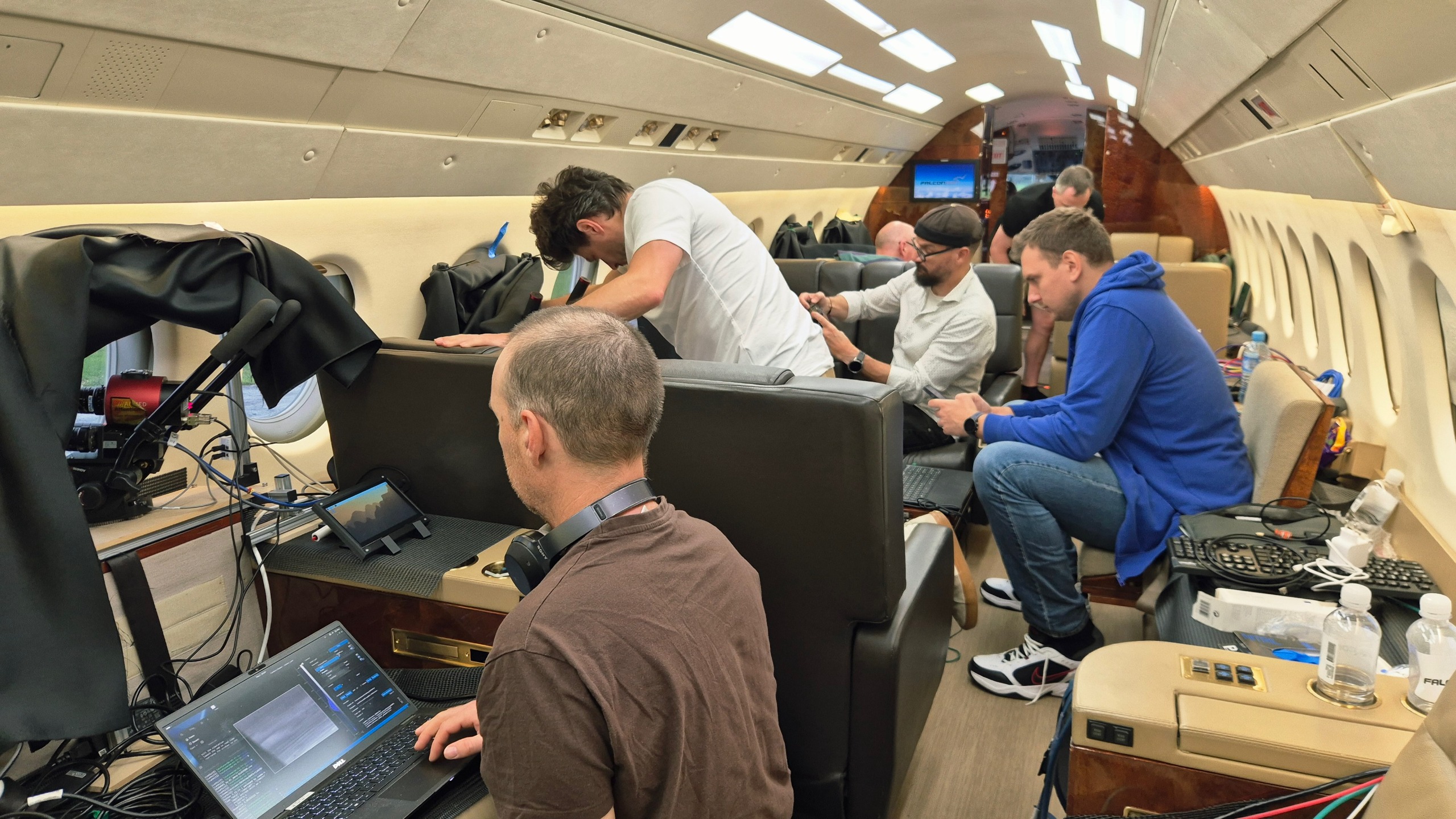 航天图片资料 · six people inside a private jet, with computer equipment strewn around the cabin