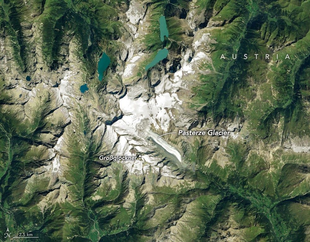 航天图片资料 · Ice in a broad Alpine basin feeds debris-covered glacial ice several kilometers long in the valley below.