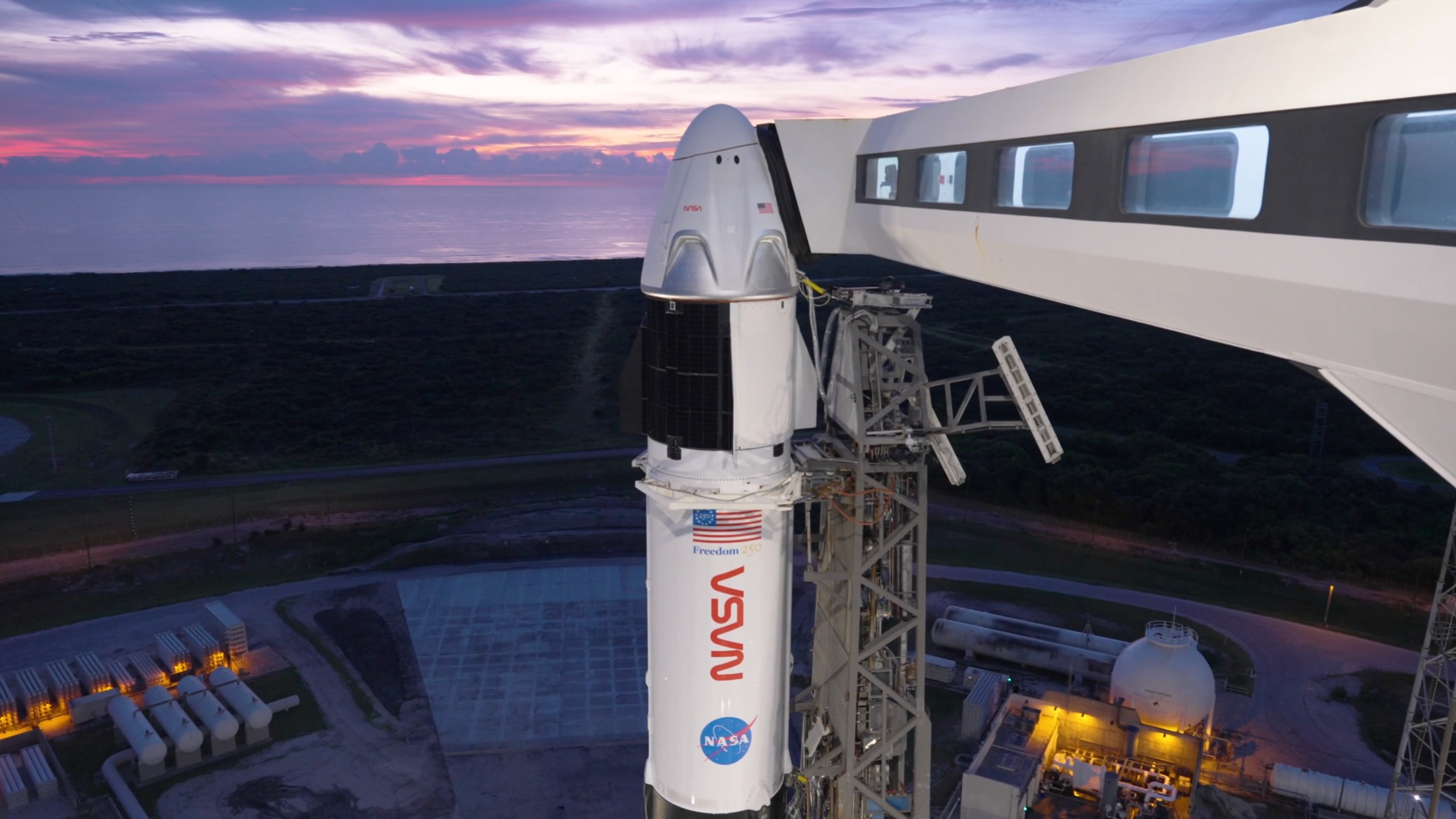 航天图片资料 · a white rocket and space capsule stand on a launch pad at dawn