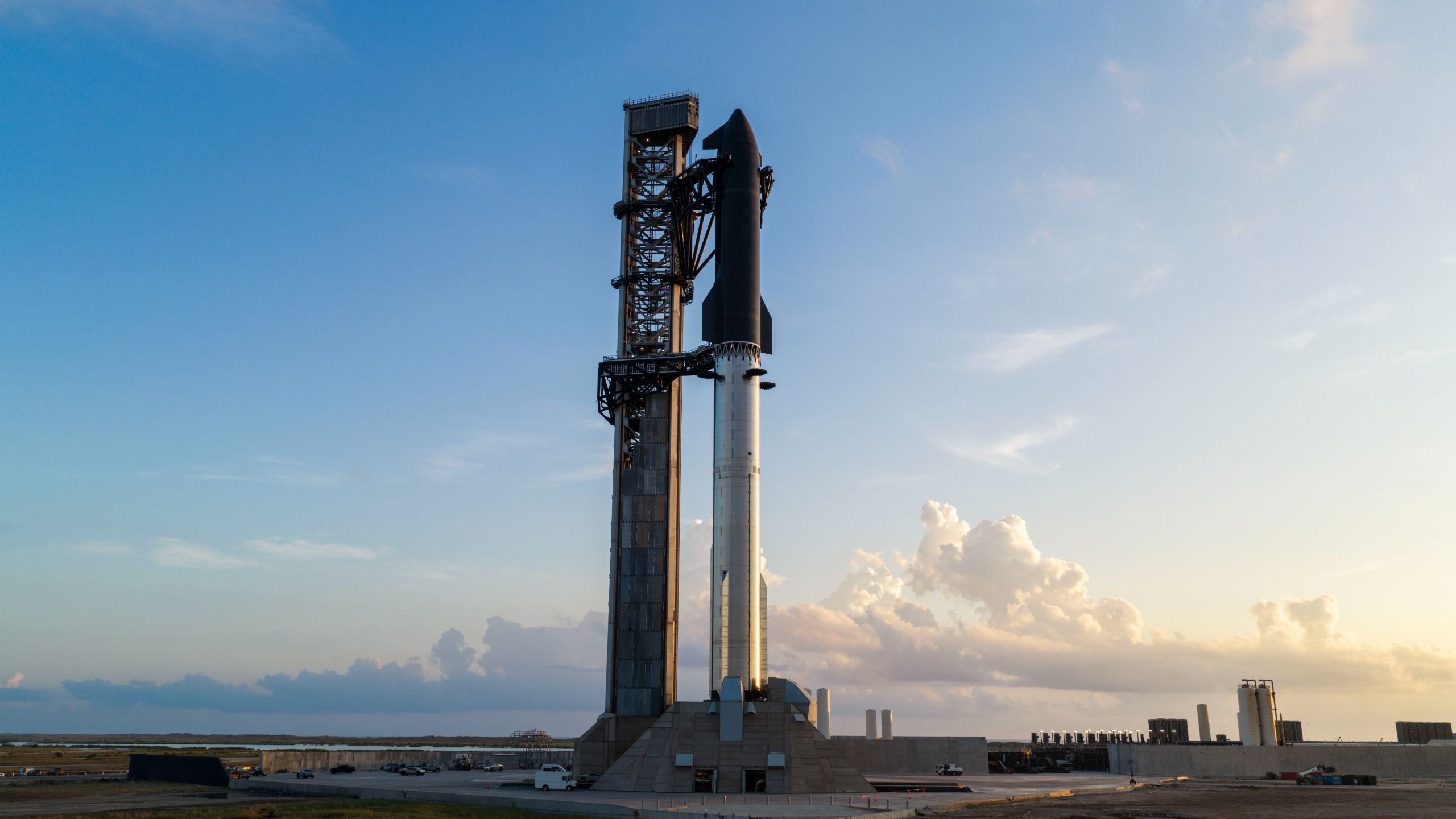 航天图片资料 · A towering SpaceX Starship rocket stands at Starbase's Pad 2 against a rich, cloudy blue sky.