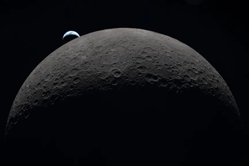 航天图片资料 · The moon as viewed from its dark side with the crescent of the Earth rising behind it.