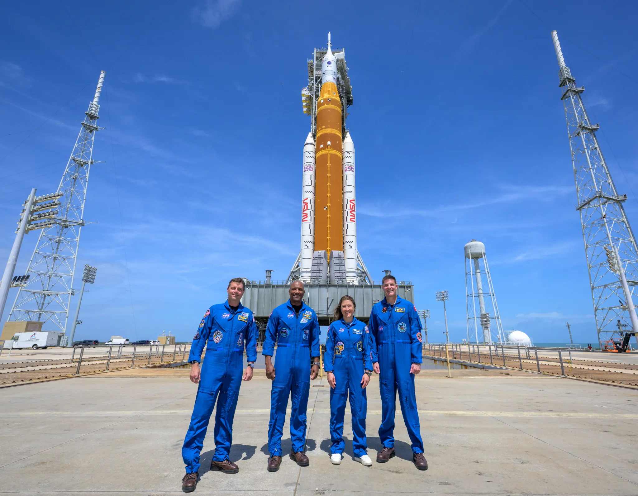 航天图片资料 · Four NASA Artemis II astronauts at the launch pad with the SLS rocket in the back.