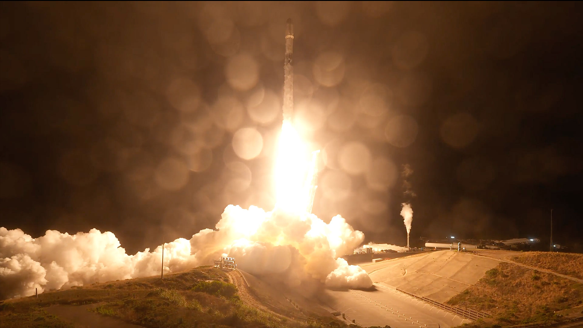 航天图片资料 · an uncrewed orbital class rocket lifts off into the pitch black sky, lighting its launch pad below with its orange-white plume