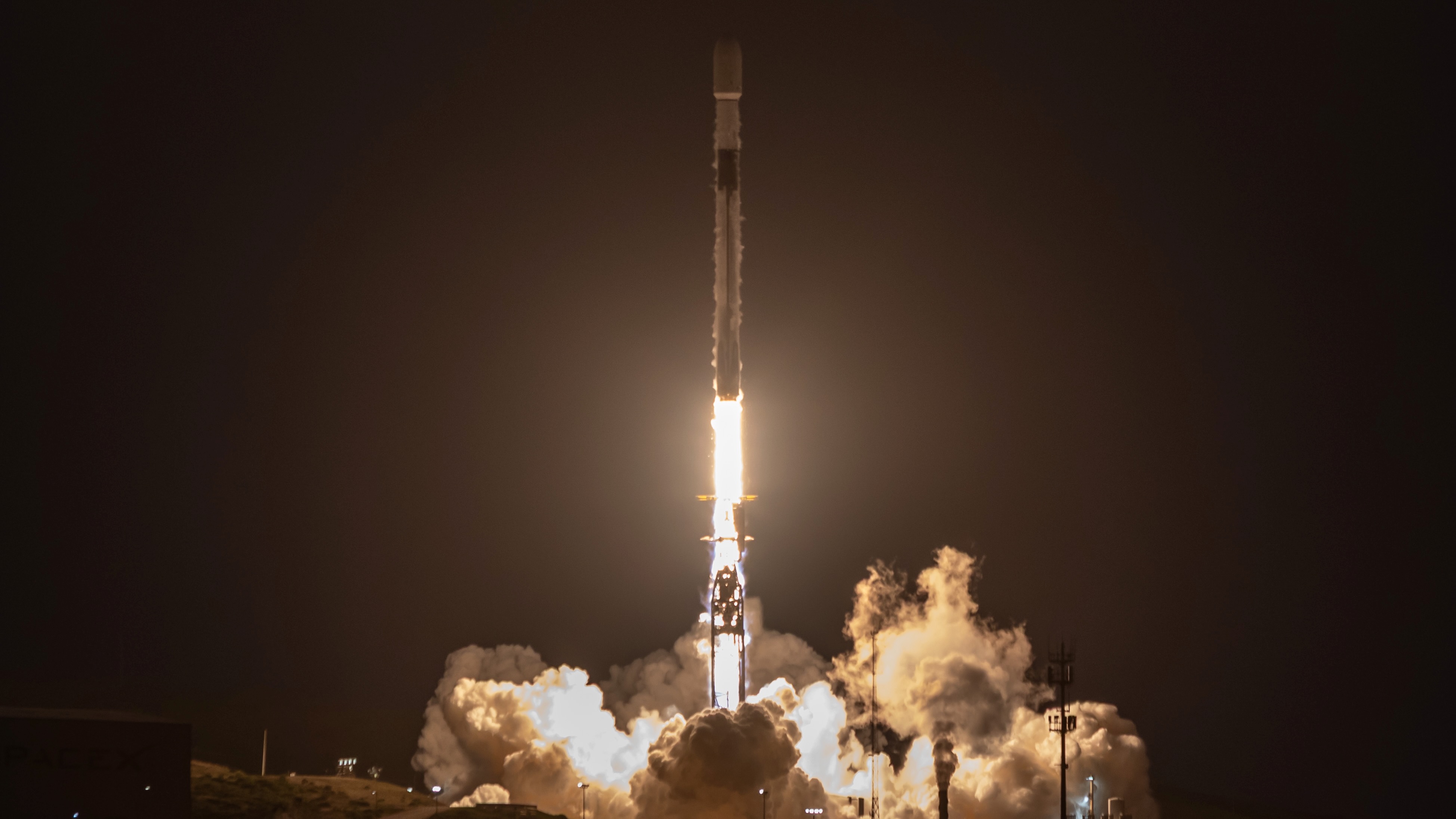 航天图片资料 · a black and white rocket launches into a dark night sky