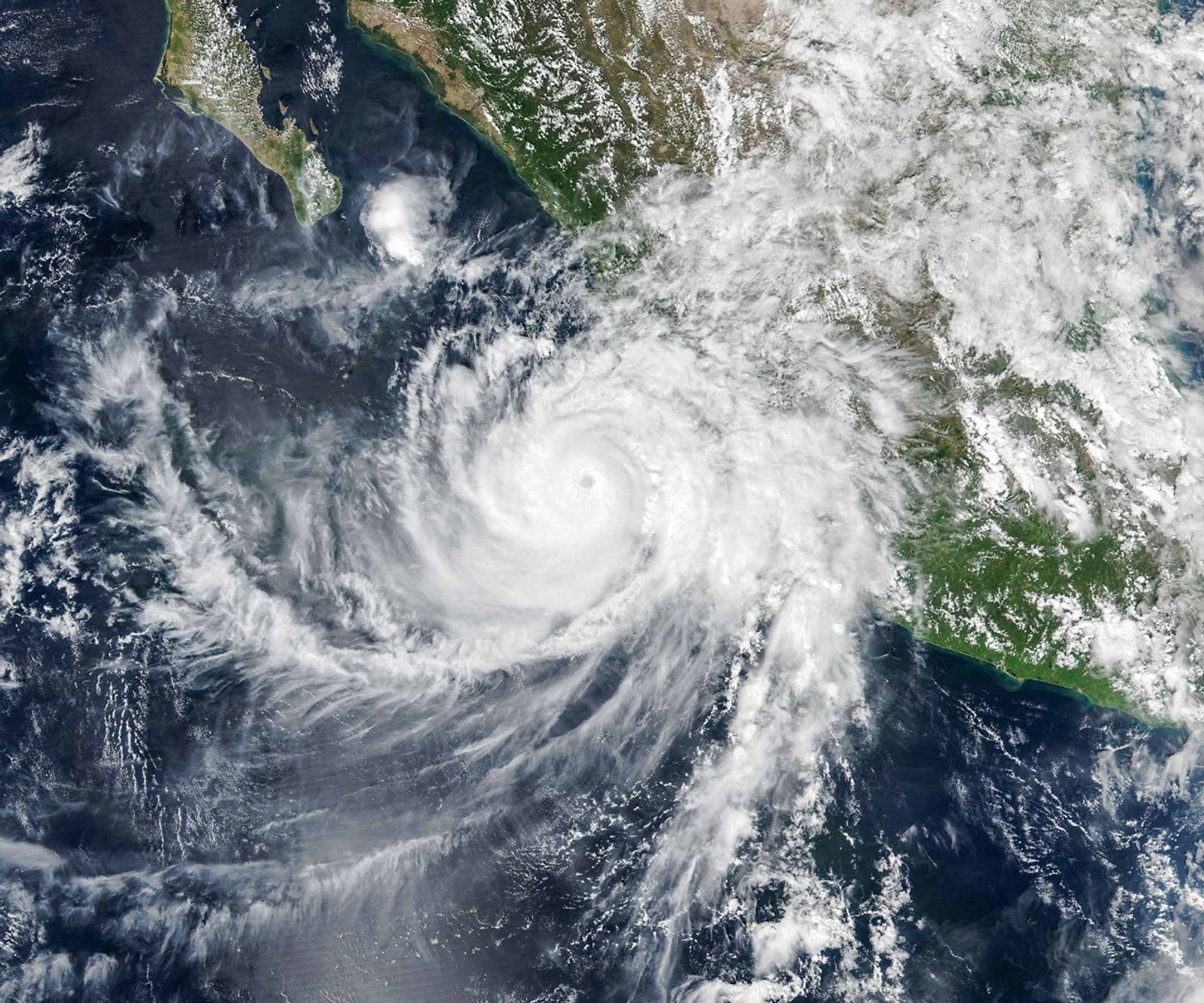 航天图片资料 · The well-defined eye of Hurricane Simon lies just off Mexico’s Pacific coast. Some outer cloud bands of the spiraling storm extend over land.