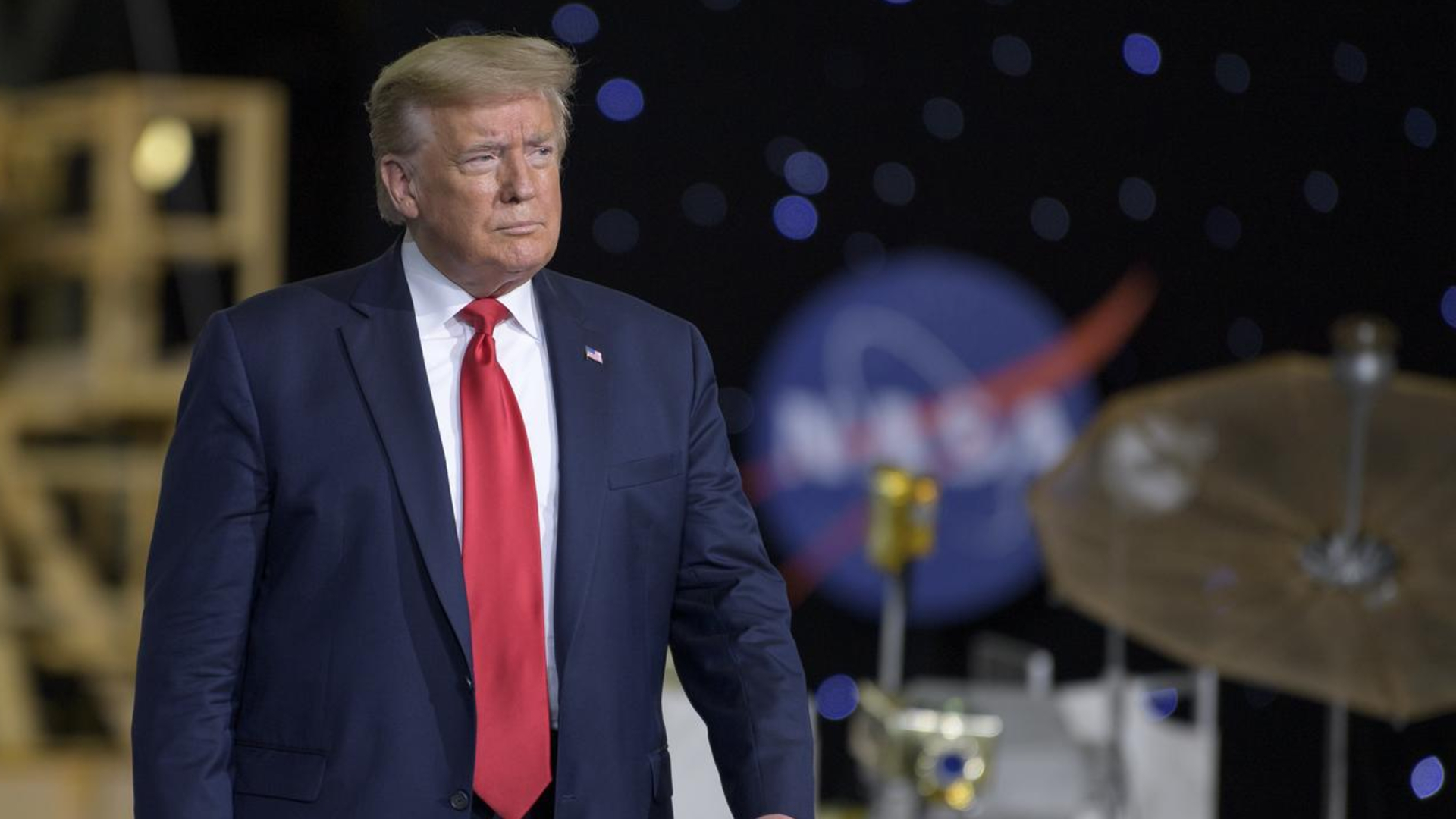 航天图片资料 · President Donald Trump in a red tie surrounded by NASA hardware