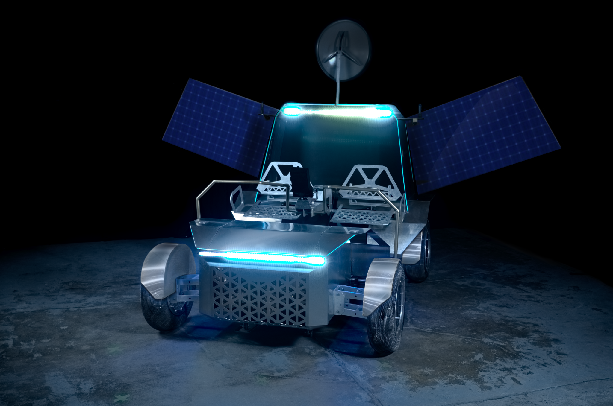 航天图片资料 · A photo of a full-scale prototype of Lunar Outpost's Pegasus lunar terrain vehicle. The rover can seat two astronauts, is fabricated out of metal, has mesh tires, has two solar arrays deployed, and is lit up by blue lights.