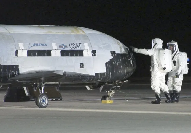 航天图片资料 · Technicians in self-contained atmospheric protective ensemble suits conduct initial checks on the X-37B Orbital Test Vehicle 1 after its landing Dec. 3, 2010, at Vandenberg Air Force Base, Calif. The X-37B conducted on-orbit experiments for more than 220 days during its maiden voyage. (U.S. Air Force photo/Michael Stonecypher) (Photo by DoD/Corbis via Getty Images)