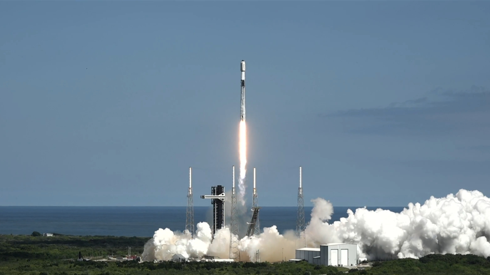 航天图片资料 · A white and black rocket lifts off against a blue sky.