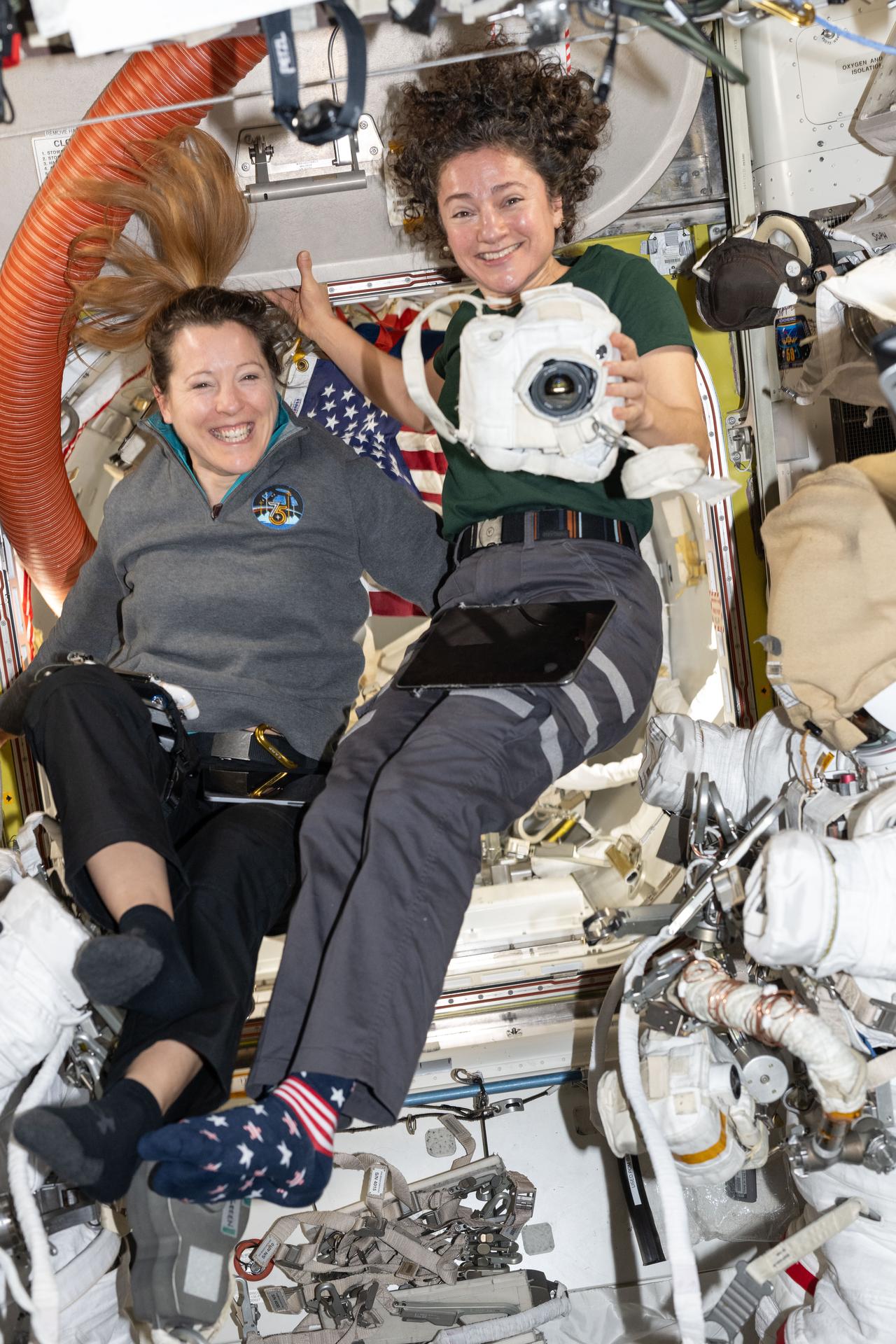 航天图片资料 · From left, Expedition 75 crewmates Sophie Adenot of ESA (European Space Agency) and Jessica Meir of NASA, flight engineer and station commander respectively, smile for a portrait while working together inside the International Space Station’s Quest airlock. Meir is holding a camera covered in a protective thermal blanket that shields it from space radiation, as the two astronauts prepare spacesuits and tools for a spacewalk they conducted together on Sept. 1.