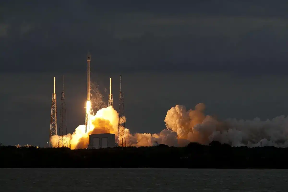 航天图片资料 · A SpaceX Falcon Heavy rocket on its launch pad at dawn, three booster cores visible, Kennedy Space Center facilities and a clear sky in the background.
