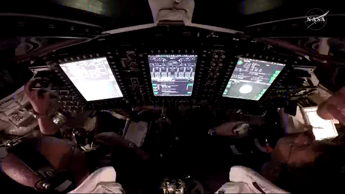 航天图片资料 · A view over the shoulders of NASA astronauts Victor Glover (left) and Reid Wiseman (right), pilot and commander, respectively, inside the Orion spacecraft as they participate in a proximity operations demonstration. This demonstration tests the spacecraft’s ability to manually maneuver relative to another spacecraft, the interim cryogenic propulsion stage, after separation, using its onboard navigation sensors and reaction control thrusters.