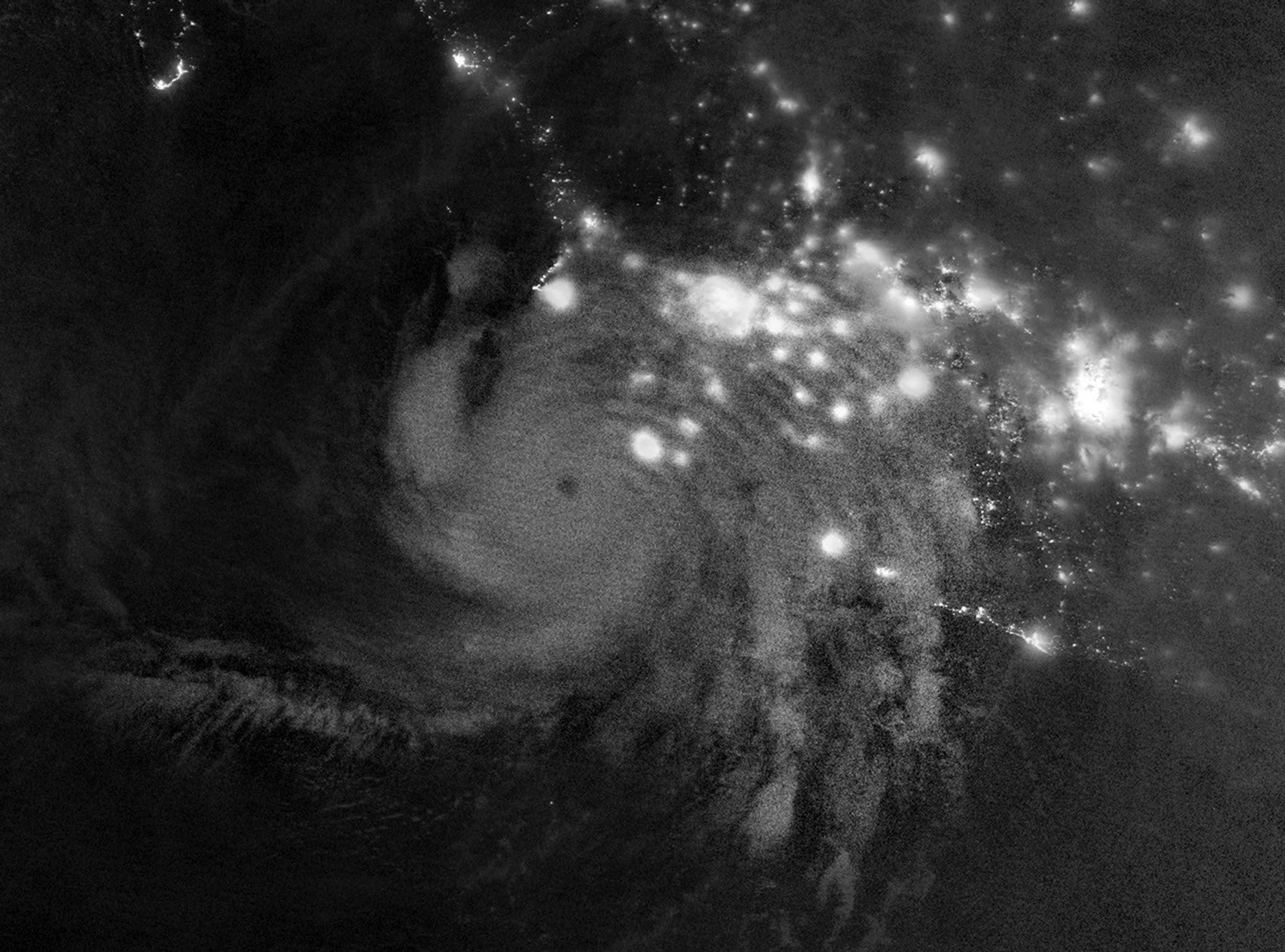 航天图片资料 · Gravity waves in the upper atmosphere appear as a semicircle of ripples in a nighttime, grayscale satellite image. Hurricane clouds and city lights in Mexico are also visible.