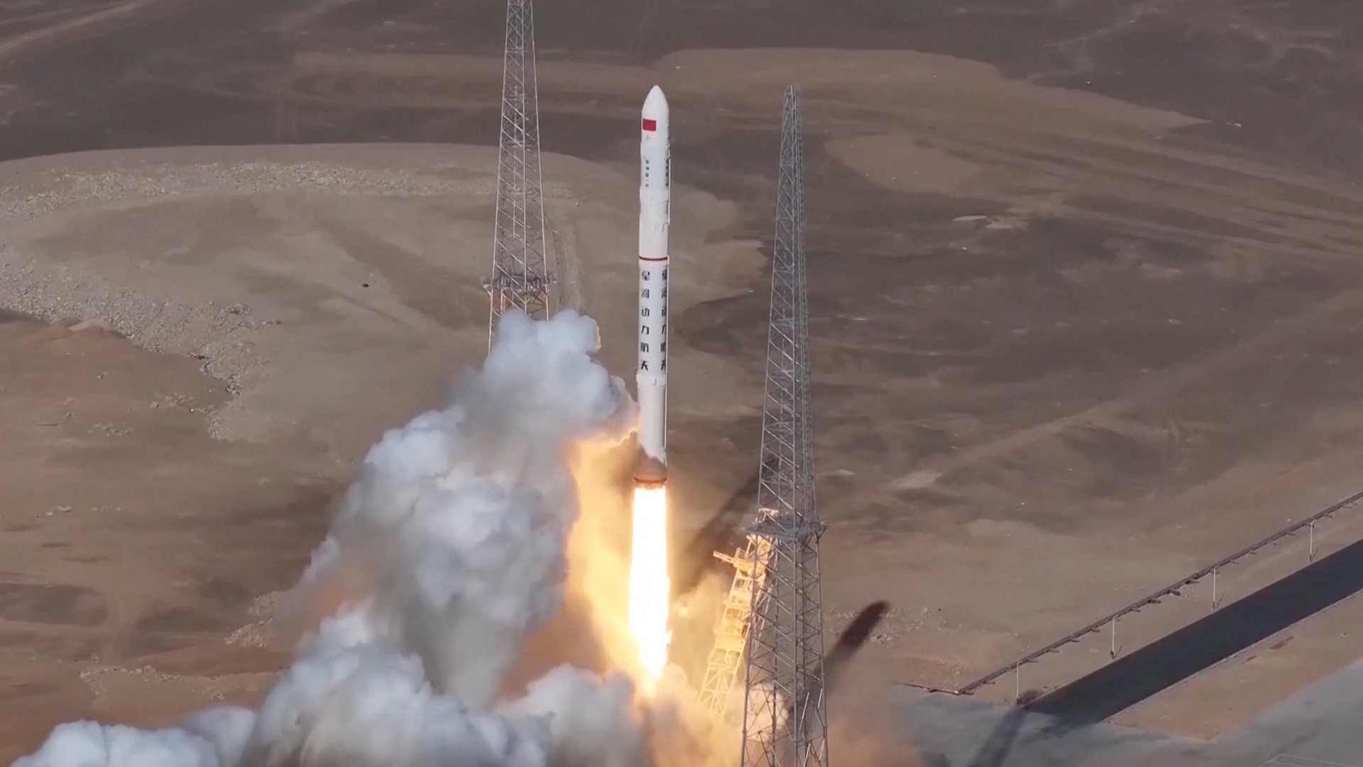 航天图片资料 · a white rocket launches from a desert pad