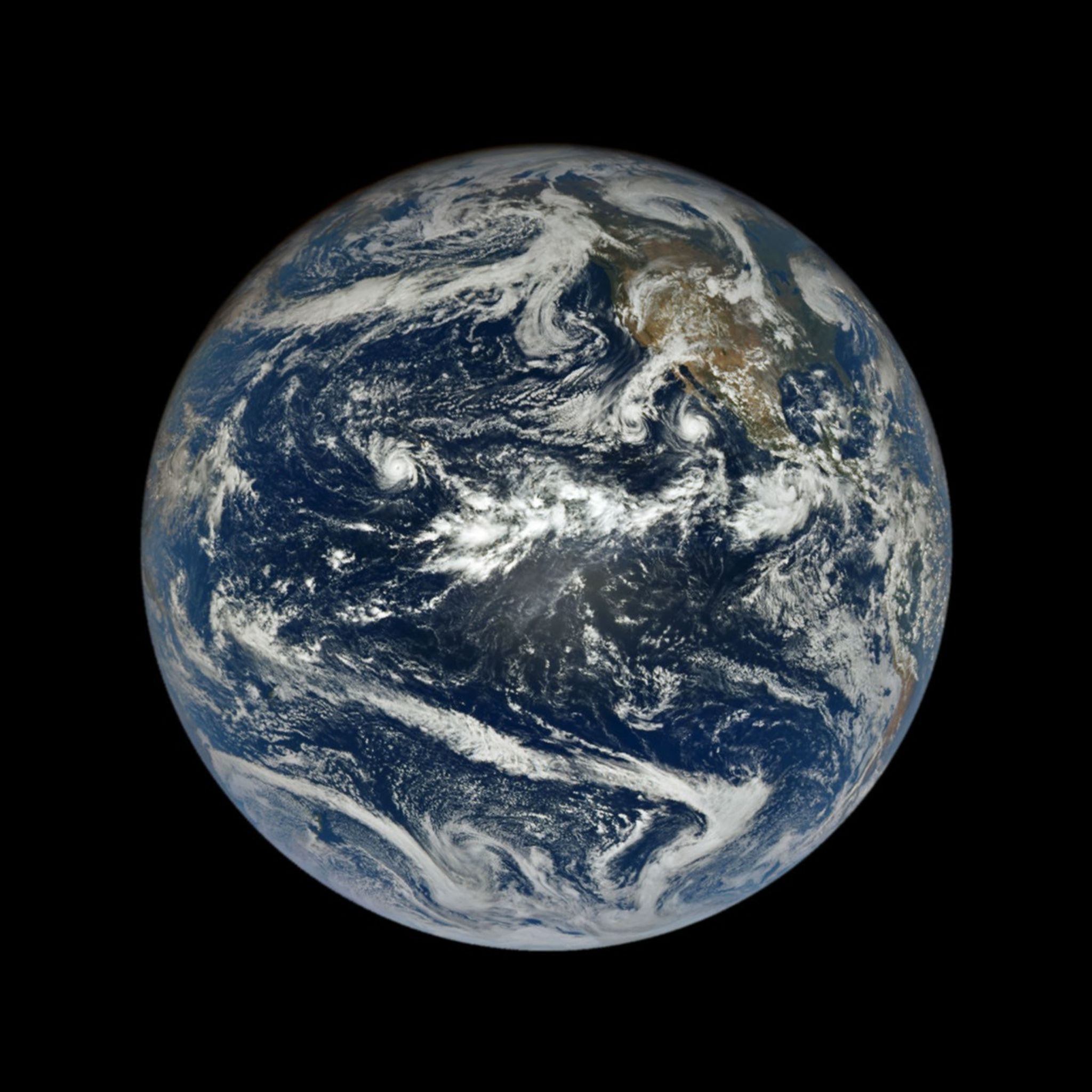 航天图片资料 · In a full-disk satellite view of Earth, several tropical cyclones swirl above the blue waters of the Pacific Ocean.