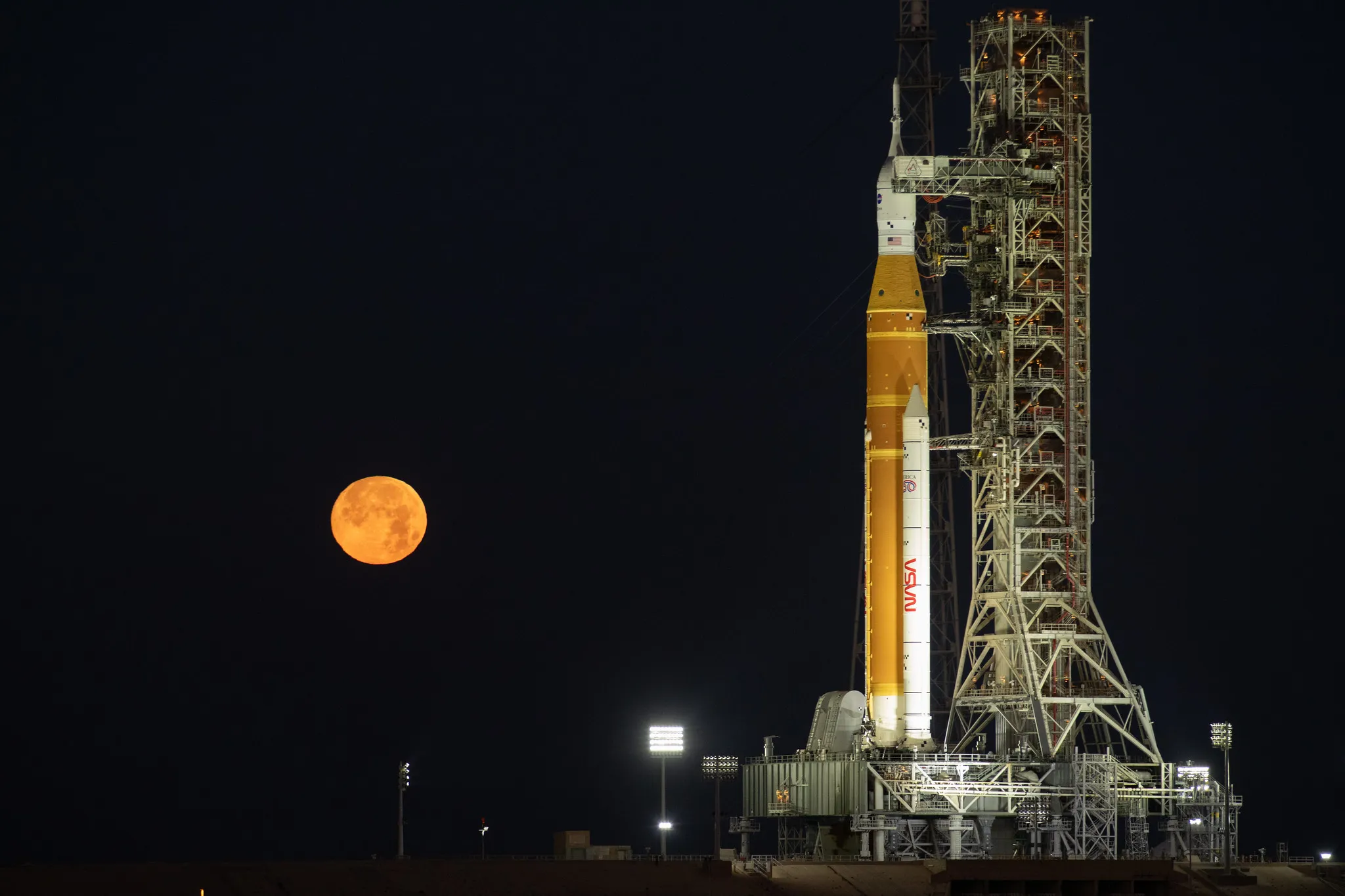 航天图片资料 · The Moon rises behind NASA’s Artemis II SLS (Space Launch System) rocket and Orion spacecraft atop a mobile launcher at Launch Complex 39B at NASA’s Kennedy Space Center in Florida on Sunday, Feb. 1,. 2026. The Artemis II test flight will take Commander Reid Wiseman, Pilot Victor Glover, and Mission Specialist Christina Koch from NASA, and Mission Specialist Jeremy Hansen from the CSA (Canadian Space Agency), around the Moon and back to Earth.