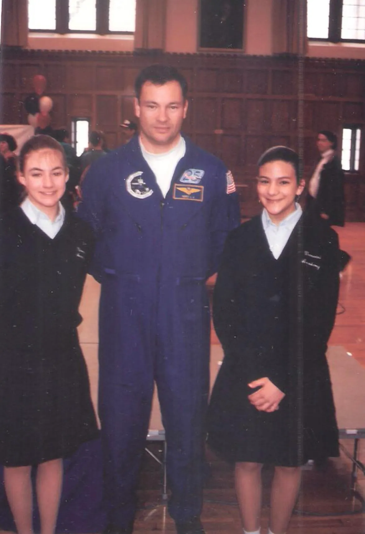 航天图片资料 · The photo features two young ladies in black dresses posing for a photograph with a NASA astronaut Michael Lopez-Alegria standing in the middle between the two young ladies.