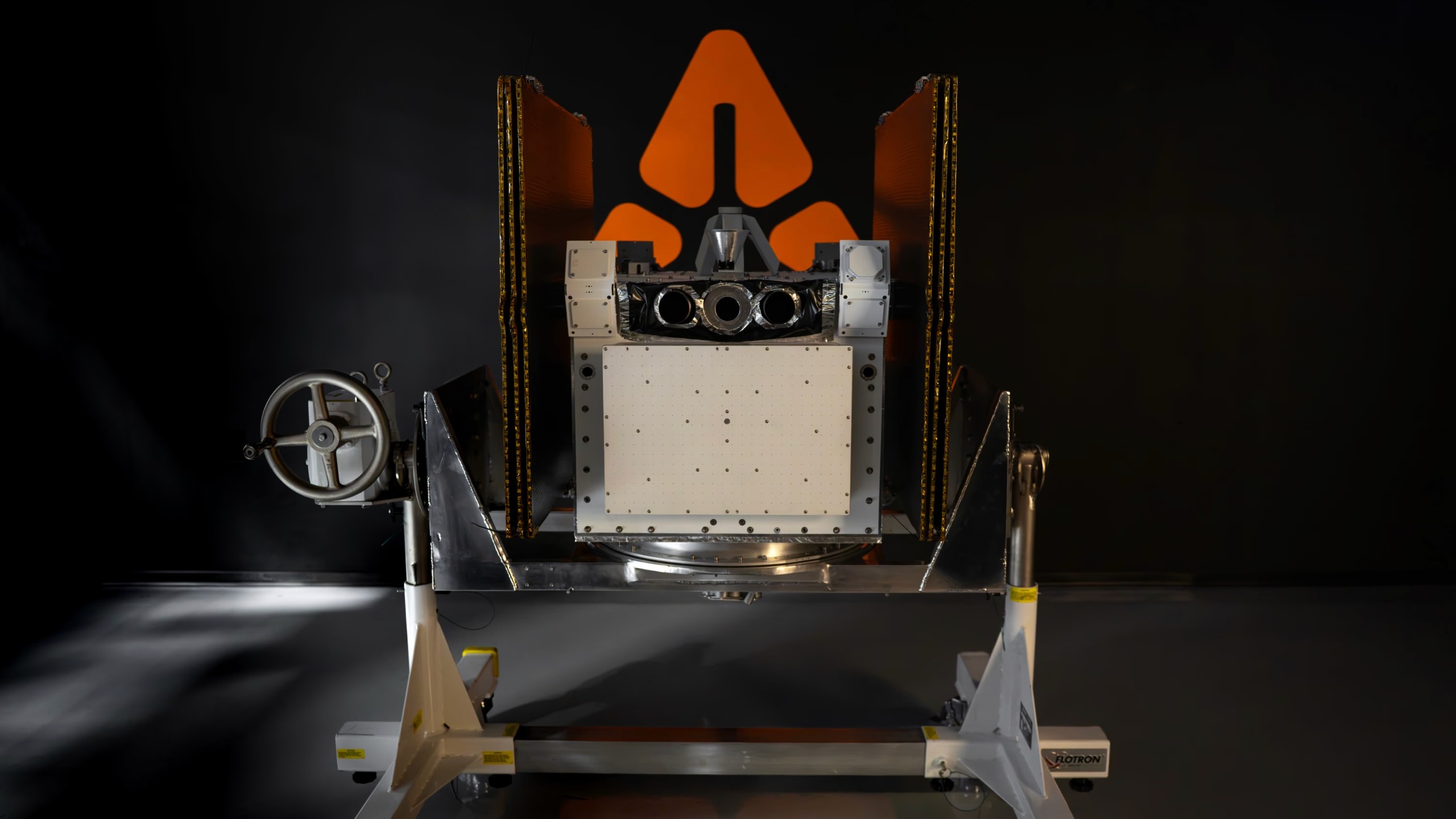 航天图片资料 · a boxy spacecraft is seen atop a metallic stand against a black backdrop