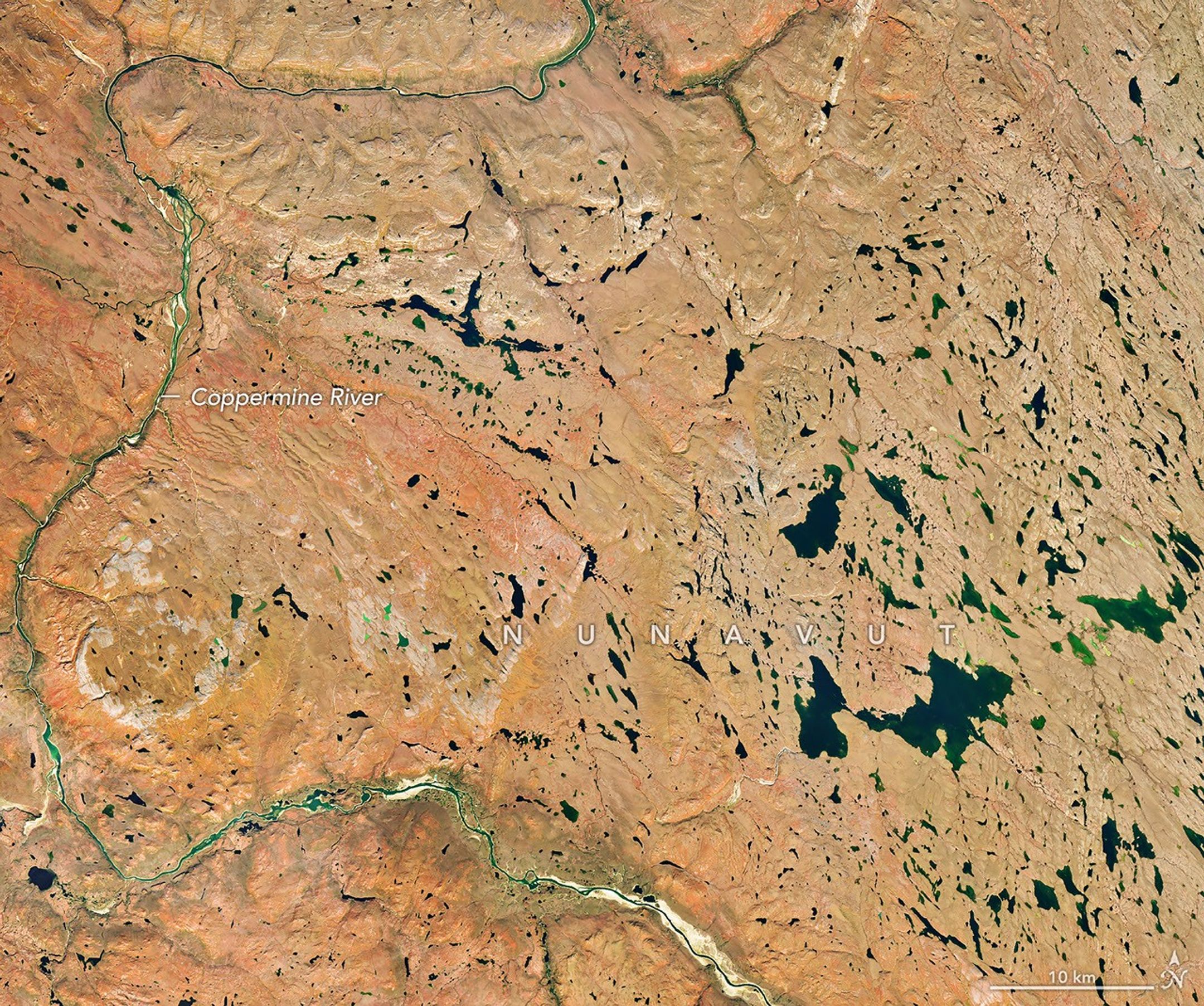 航天图片资料 · A river winds through the same tundra landscape in autumn, now colored red and orange. Some green vegetation remains visible along the river.