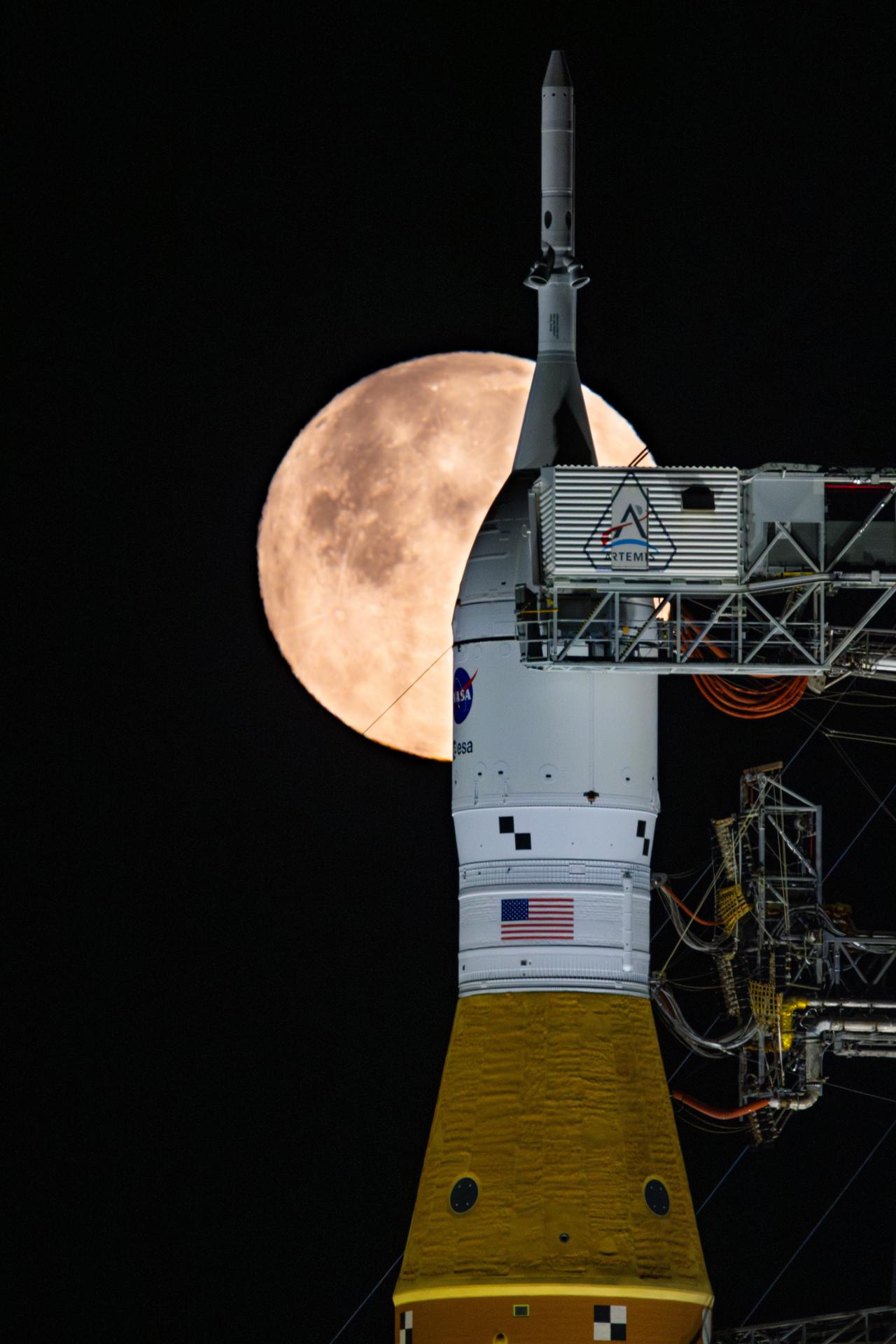 航天图片资料 · A full Moon is seen shining over NASA’s SLS (Space Launch System) and Orion spacecraft, atop the mobile launcher in the early hours of February 1, 2026. The rocket is currently at Launch Pad 39B at NASA’s Kennedy Space Center in Florida, as teams are preparing for a wet dress rehearsal to practice timelines and procedures for the launch of Artemis II.