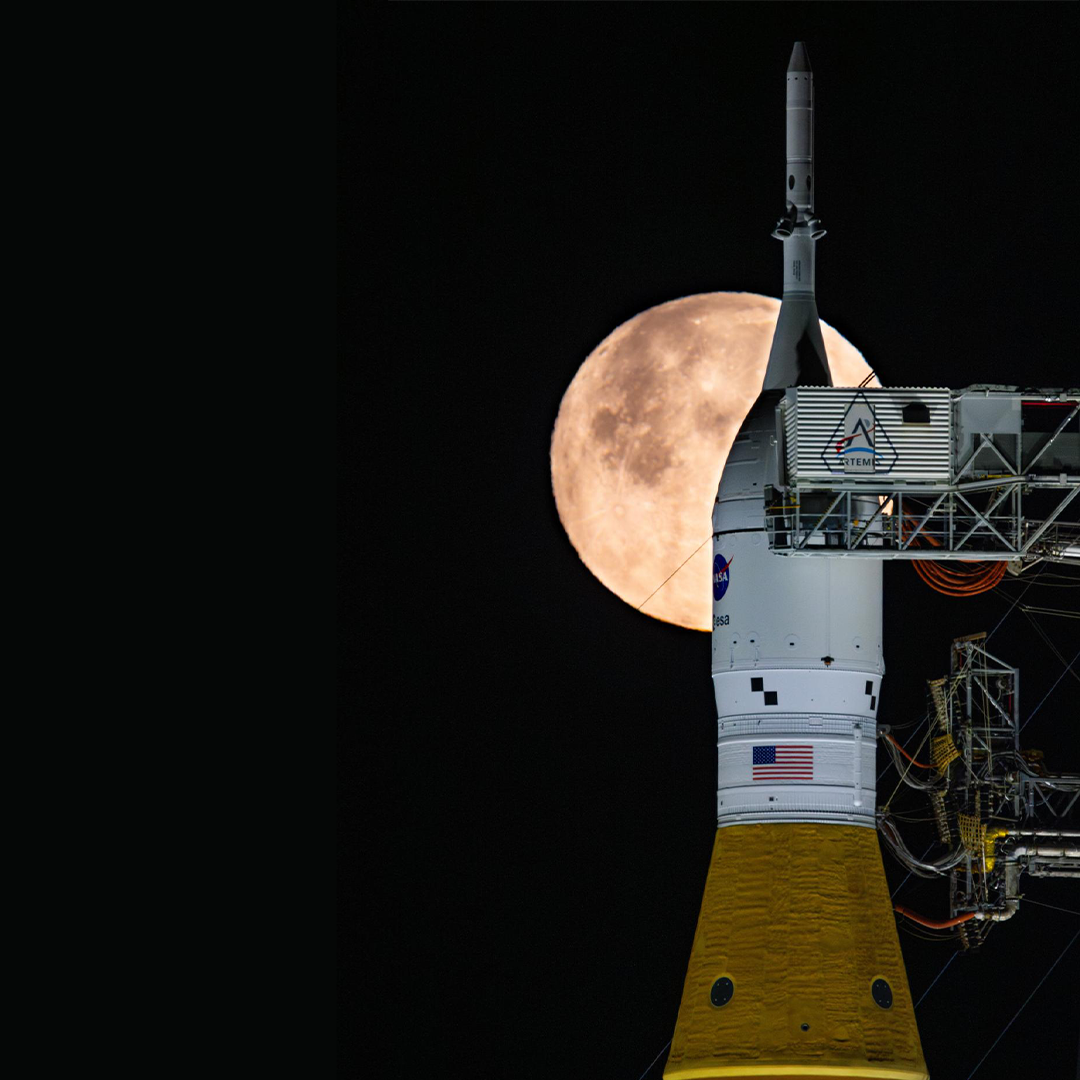 航天图片资料 · The tip of a rocket at the launch pad with a bright full Moon shining in the night sky behind it.