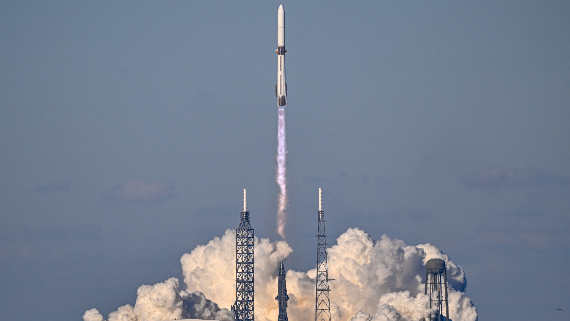 航天图片资料 · a white and blue rocket lifts off above a plume of fire