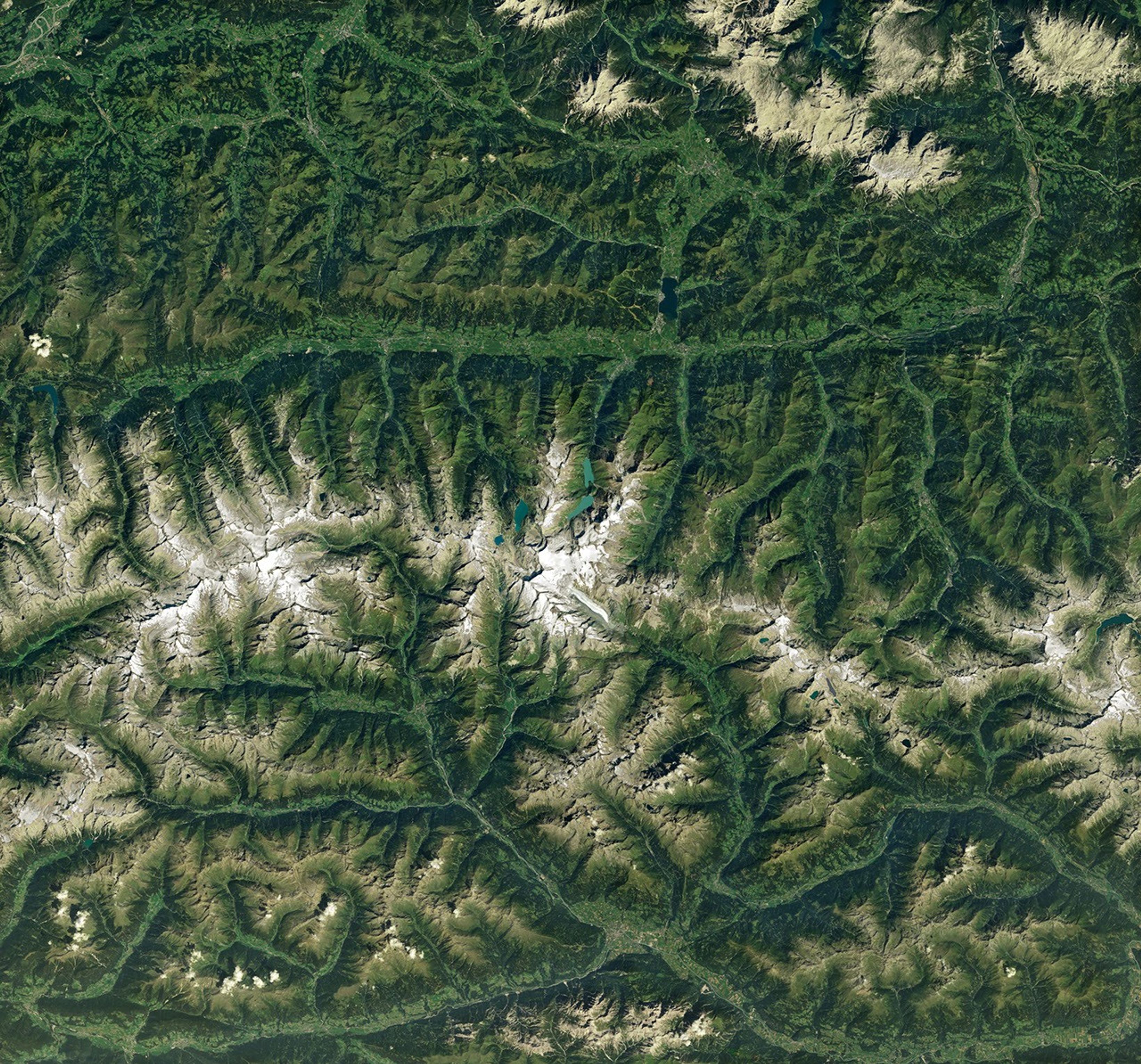 航天图片资料 · Ice in a broad Alpine basin feeds debris-covered glacial ice several kilometers long in the valley below.