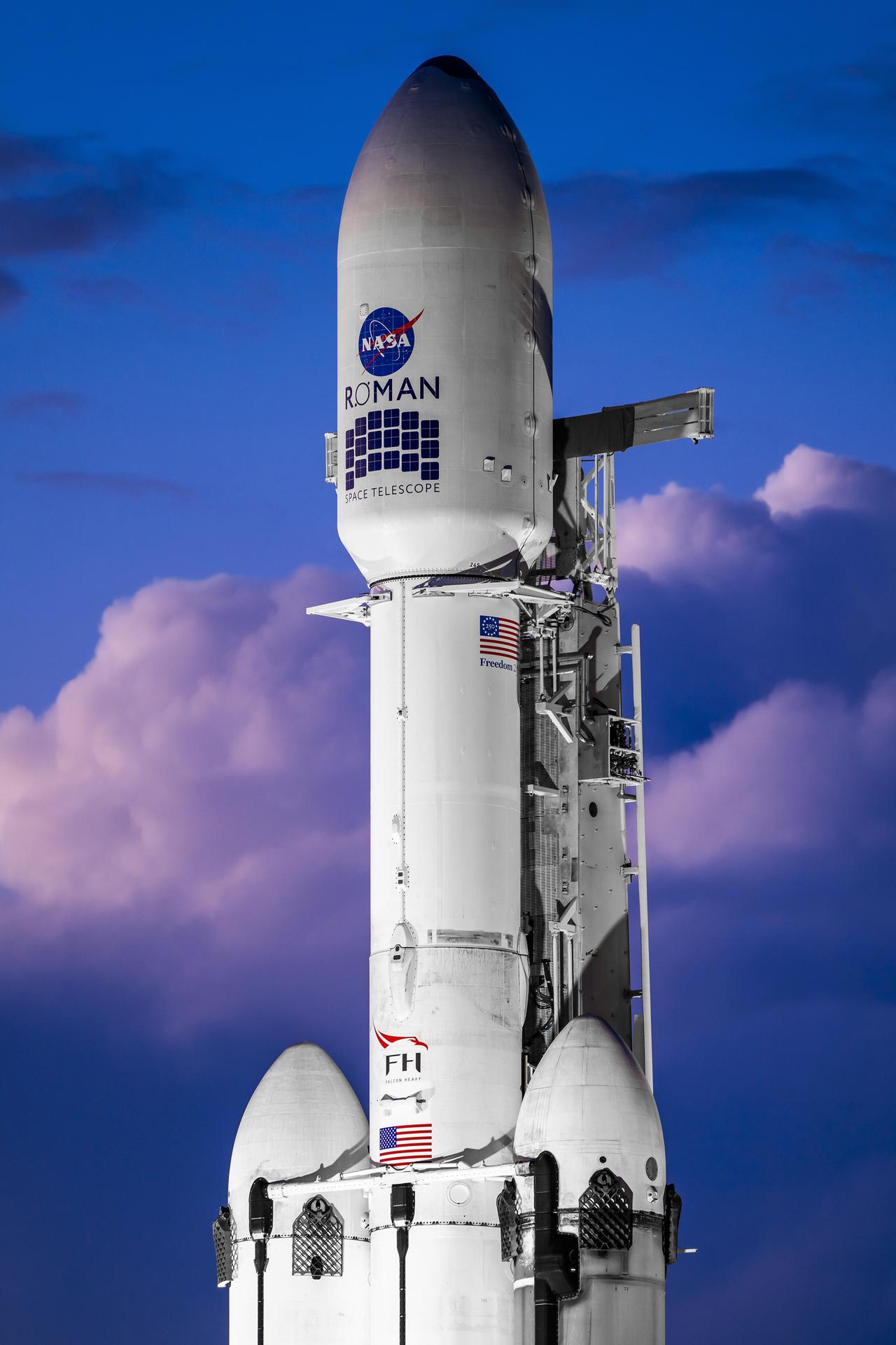 航天图片资料 · A white SpaceX Falcon Heavy rocket stands vertical on the black launch pad with a predawn sky in the background.