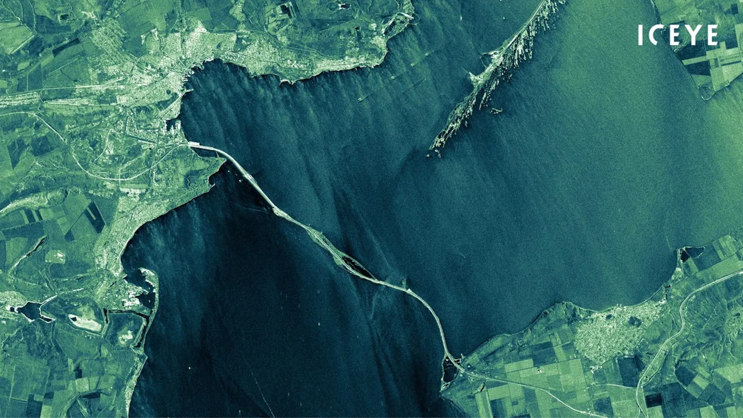 航天图片资料 · greenish-tinted satellite image of a bridge over an inland sea