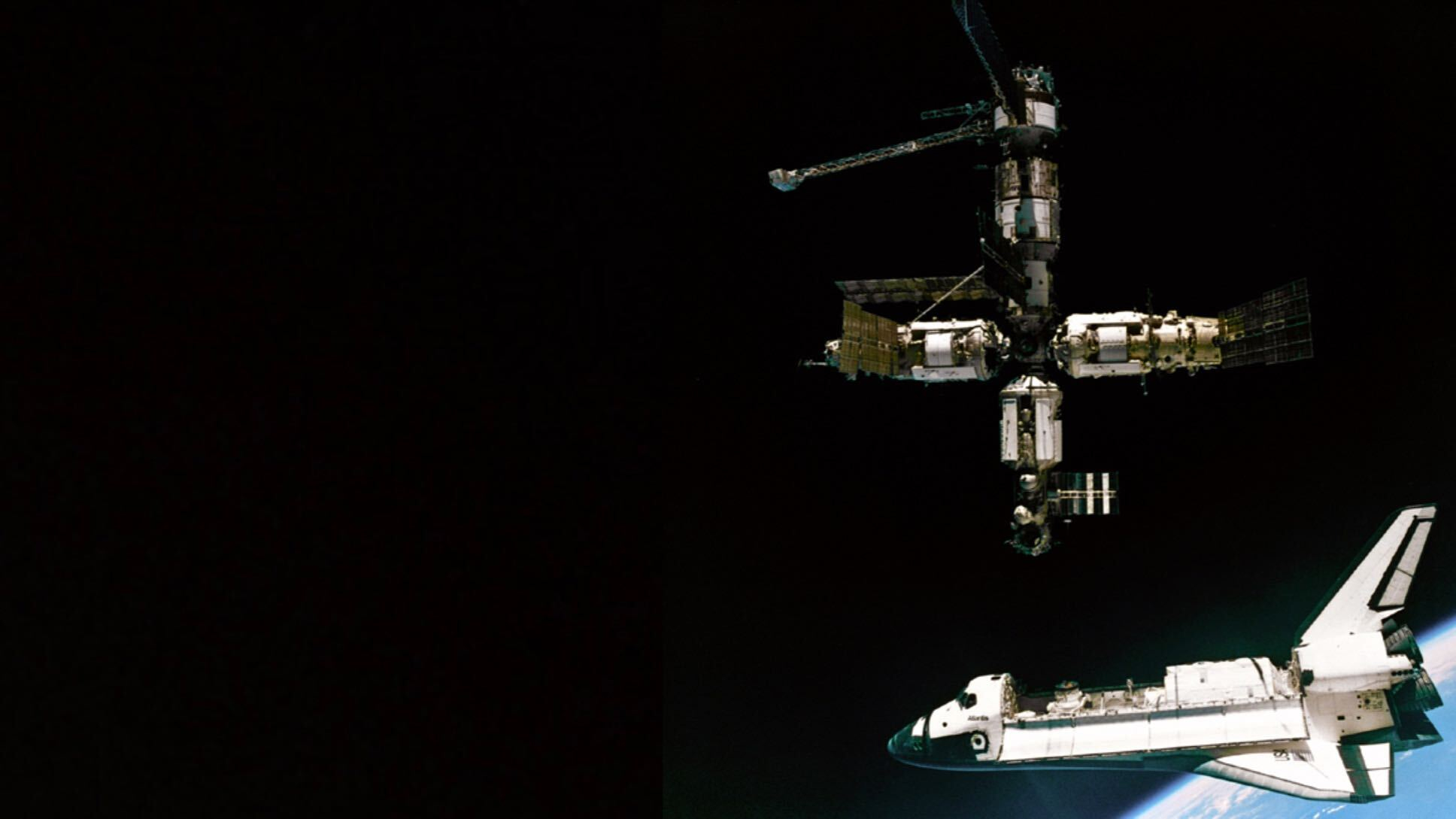 航天图片资料 · a space shuttle with open cargo bay hangs separated from a space station floating above.