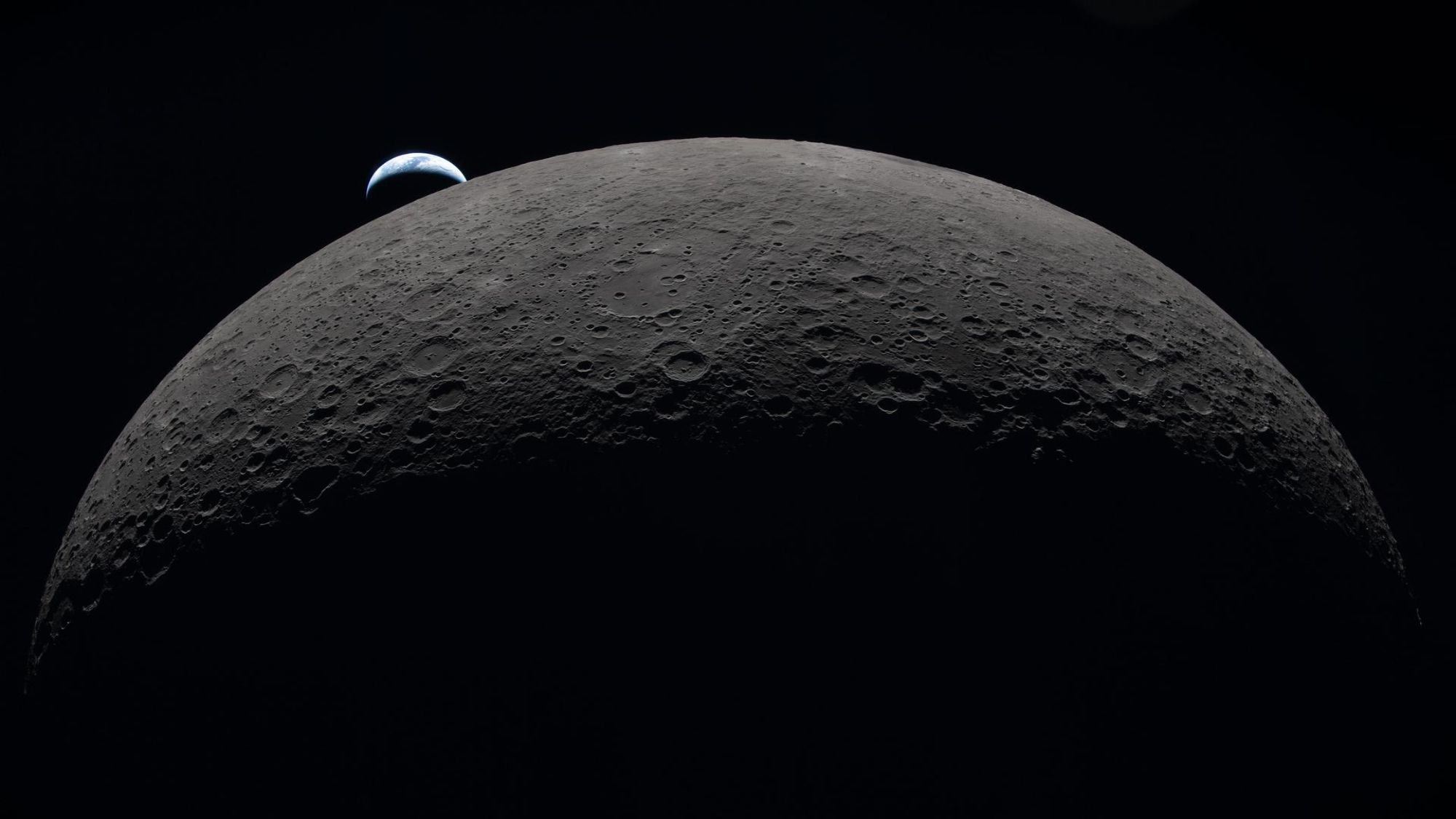 航天图片资料 · A view of the moon in the foreground with a small Earth in the background.