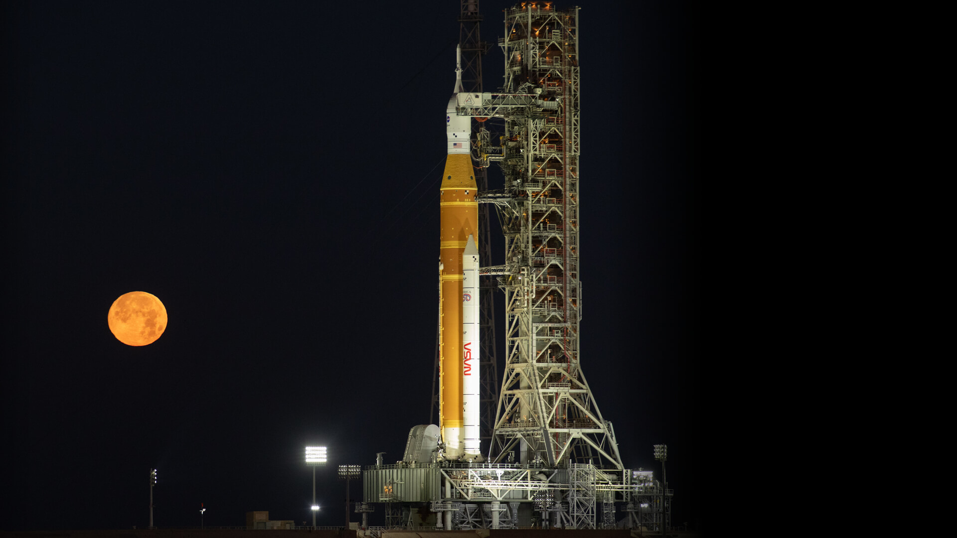 航天图片资料 · NASA Space Launch System rocket on the launchpad at night with a full moon in the background.
