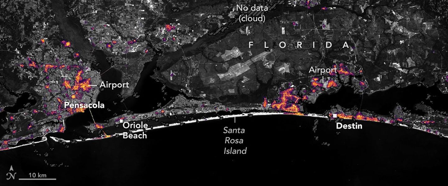 航天图片资料 · Nighttime lights along the Florida Panhandle coast on October 11, 2026, after Hurricane Isaias, with fewer and dimmer lights in Pensacola and Destin and gaps along the road between them.