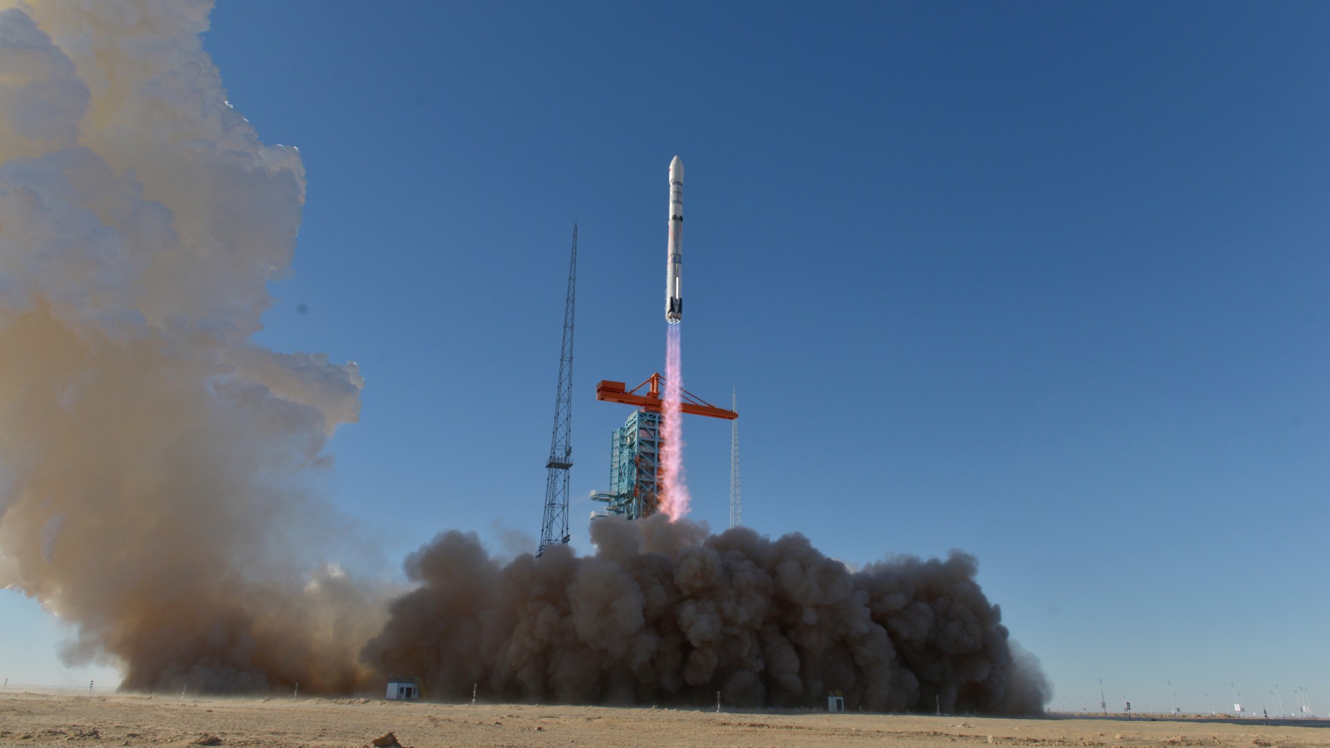 航天图片资料 · a white rocket lifts off above a cloud of dust and smoke in the desert